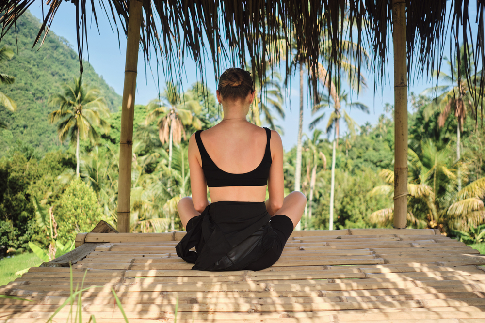 Back view of beautiful girl relaxing with amazing view on tropical island