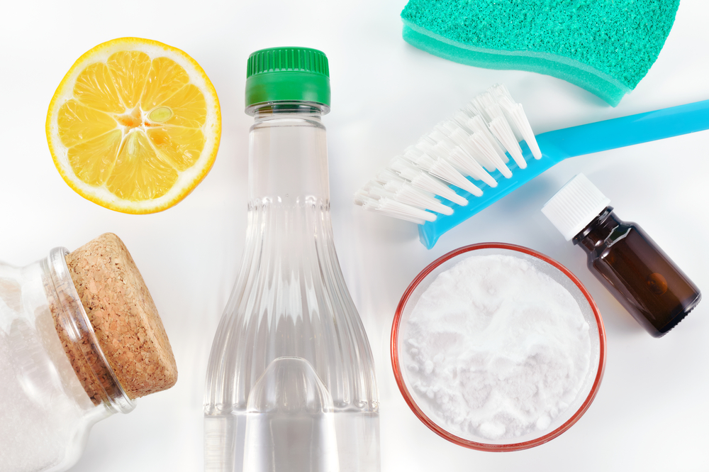 Eco-friendly natural cleaners. Vinegar, baking soda, salt, lemon and essential oil. Homemade green cleaning on white background.
