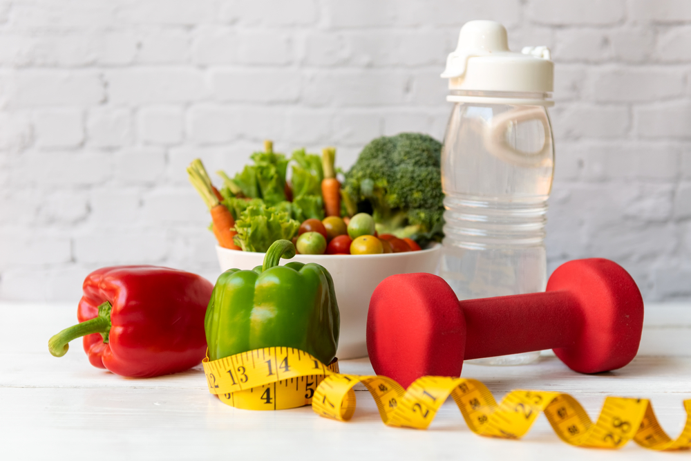 Diet Healthy food and lifestyle health concept. Sport exercise equipment workout and gym background with nutrition detox salad for fitness style. Healthy Concept