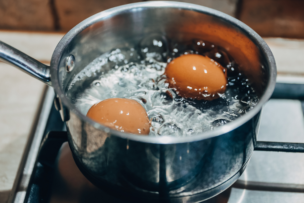 Saucepan with boiling eggs on a gas stove
