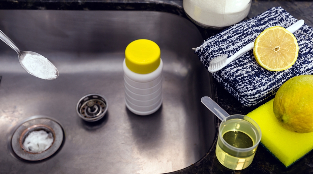 clogged kitchen sink, dirty pipe being cleaned at home with baking soda, lemon and vinegar
