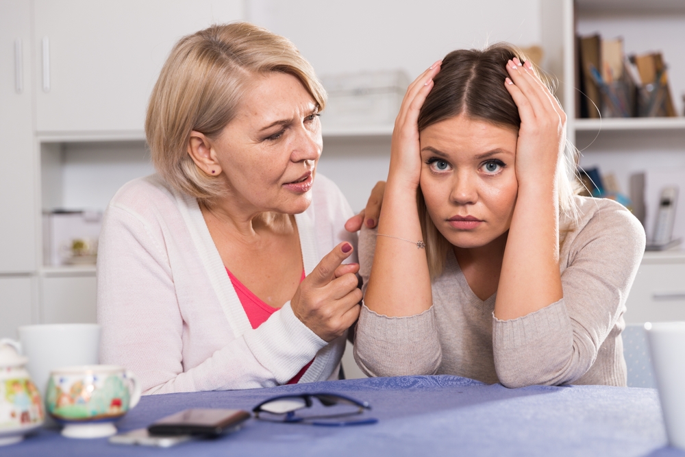 Angry mother scolds her adult sad daughter