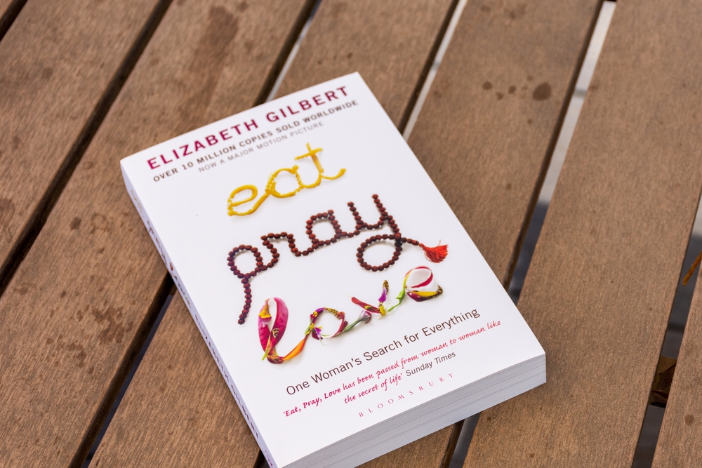 Setif, Algeria - June 9, 2021: Close-up of Elizabeth Gilbert's "Eat, Pray, Love" book on a wooden table.