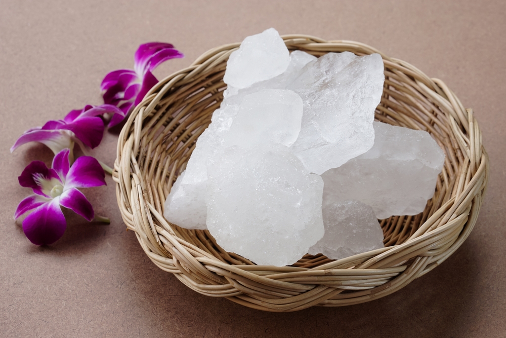Crystal clear alum stones or Potassium alum on basket, decorated with flowers. Useful for beauty and spa treatment. Use to treat body odor under the armpits as deodorant and make water clear.
