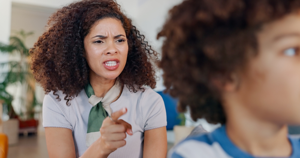 Mother, shouting and boy in lounge, angry and discipline of child with disrespect in house. Scolding, kid and upset in living room of home, pointing and talk for conflict with mom, youth and parent