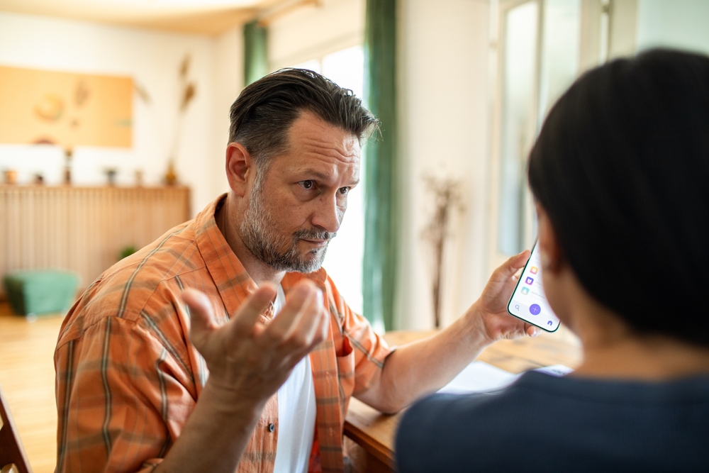 Couple having serious conversation about bills in kitchen at home