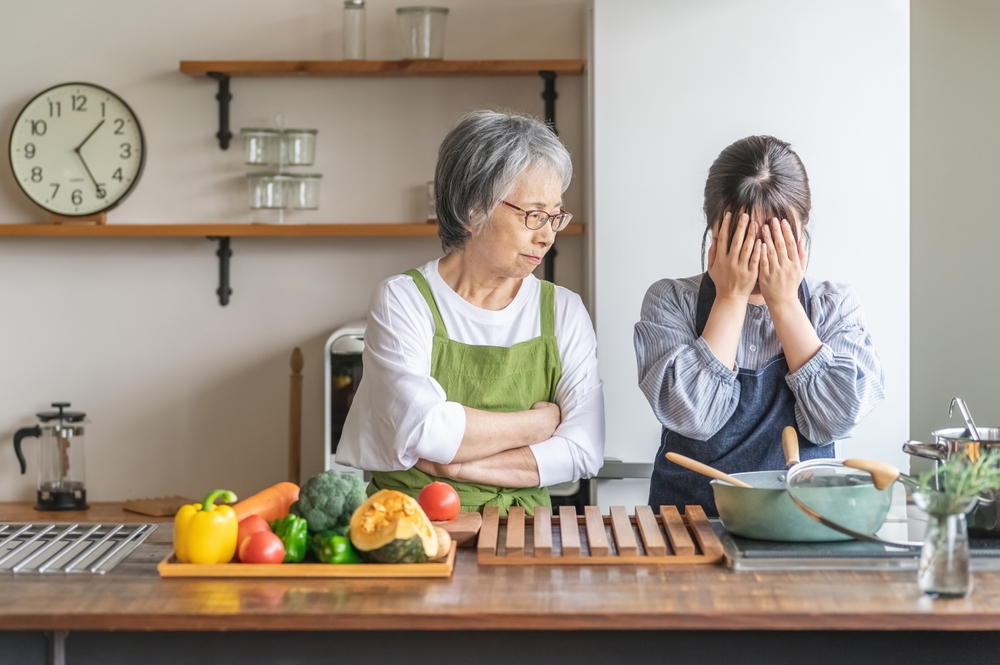 An elderly woman complains about the food she is cooking and a young woman cries (daughter-in-law abuse)