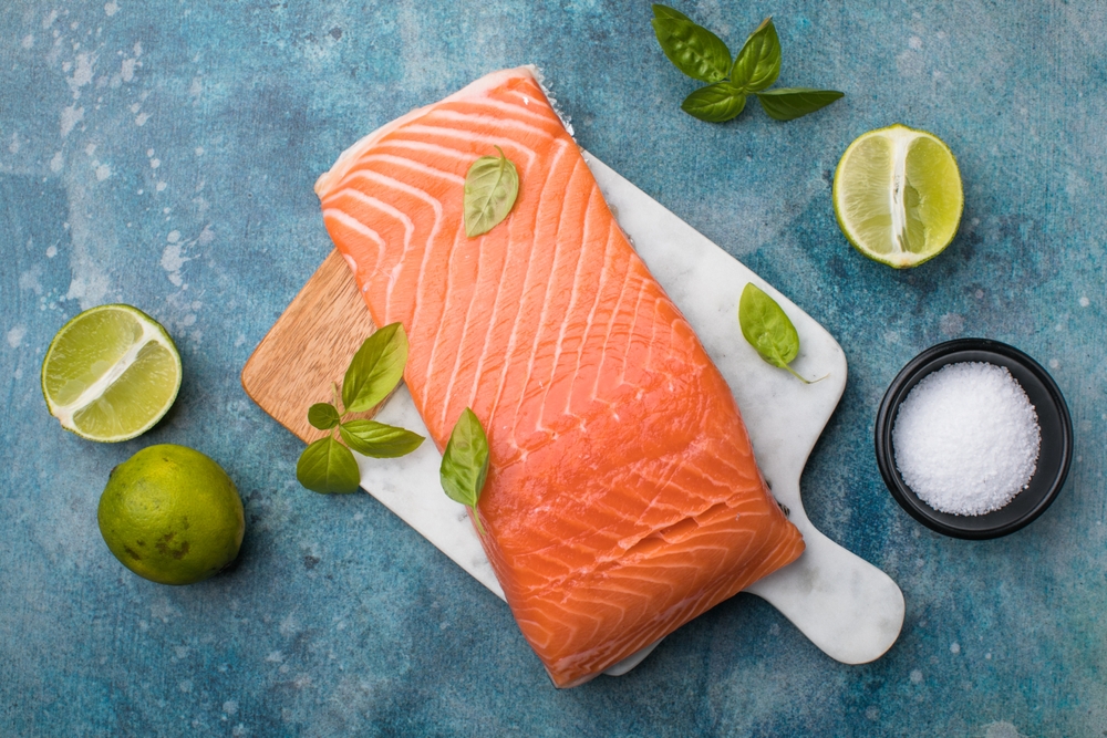 Salmon. Fresh raw salmon fish fillet with cooking ingredients on stone background, top view