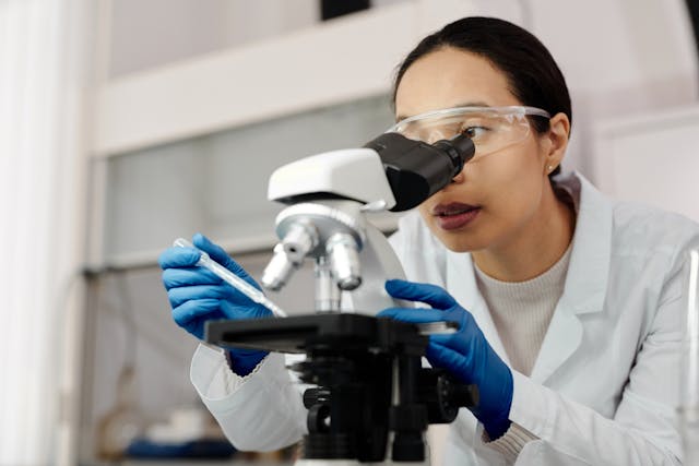 researcher looking into microscope