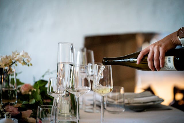 man pouring glass of wine