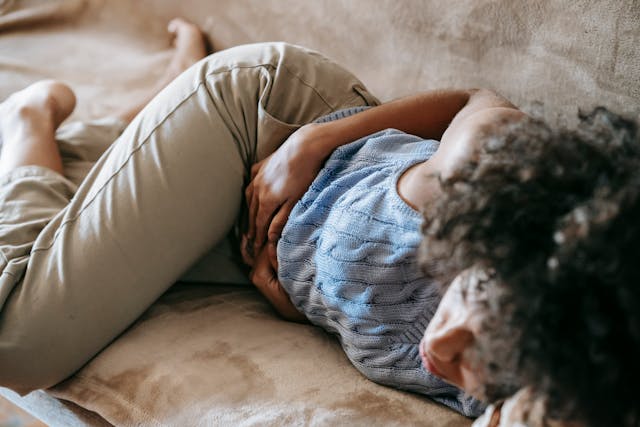 woman with cramps lying on couch