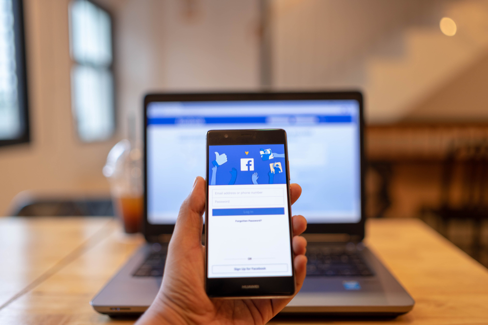 CHIANG MAI, THAILAND - June 03,2018: Man hands holding HUAWEI with facebook app on the screen. Facebook is a popular free social media are used for information sharing and networking.