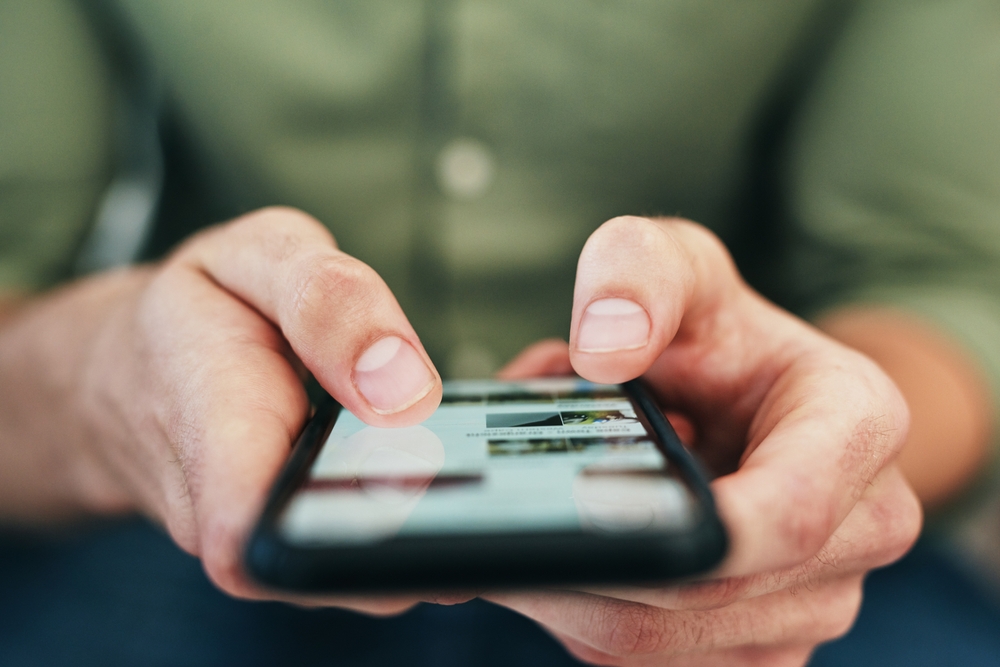 Man, hands and typing with phone screen for online browsing, communication or social media. Closeup, male person or user scrolling with mobile smartphone on website or app for texting or research