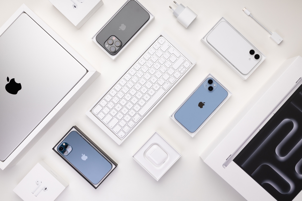 Prague, Czechia – 4.12.2025: Apple devices including iPhones, iPad, MacBook and wireless AirPods are arranged on a white table, highlighting their sleek design and innovative technology background
