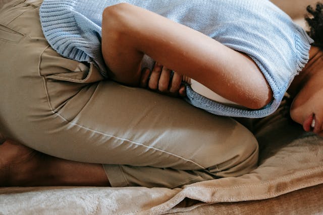 Woman lying on couch in pain
