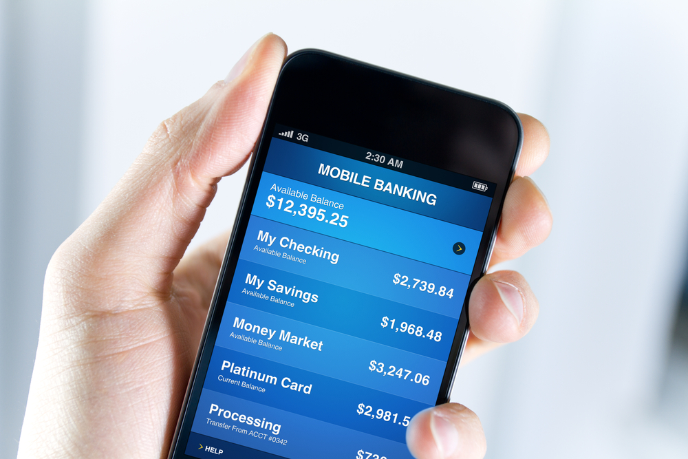 A man holding mobile smart phone with mobile banking application on a screen. Closeup shot.