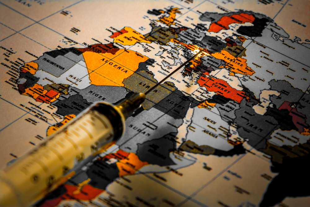 A single syringe with a needle is on the political map of the world