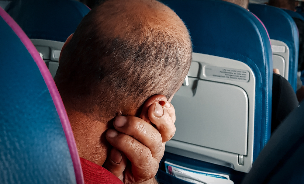 A man In his back who sleeps in the aircraft's cabin during flight to Europe