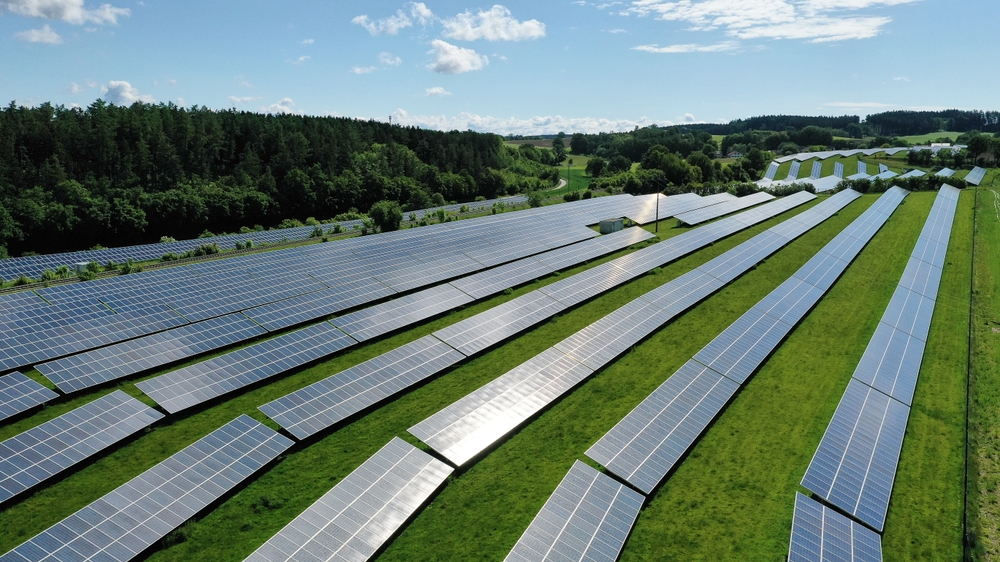 This stunning aerial view captures an expansive solar field, showcasing a vast array of solar panels harnessing the sun's energy.