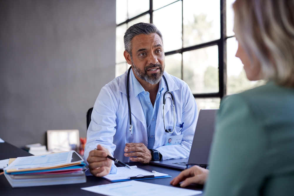 Middle eastern doctor attentively listening to a patient and providing advice. Healthcare general practitioner explaining medical options in a private appointment with his patient, consultation.