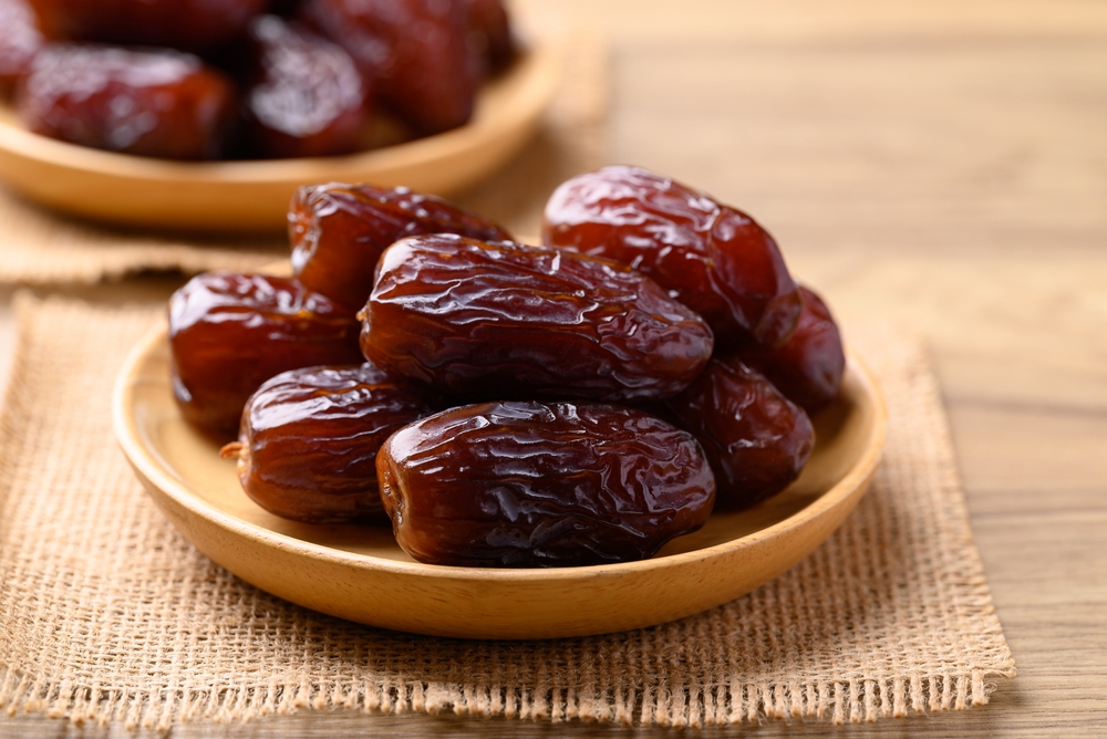 Date palm fruit (MedJool) on wooden plate