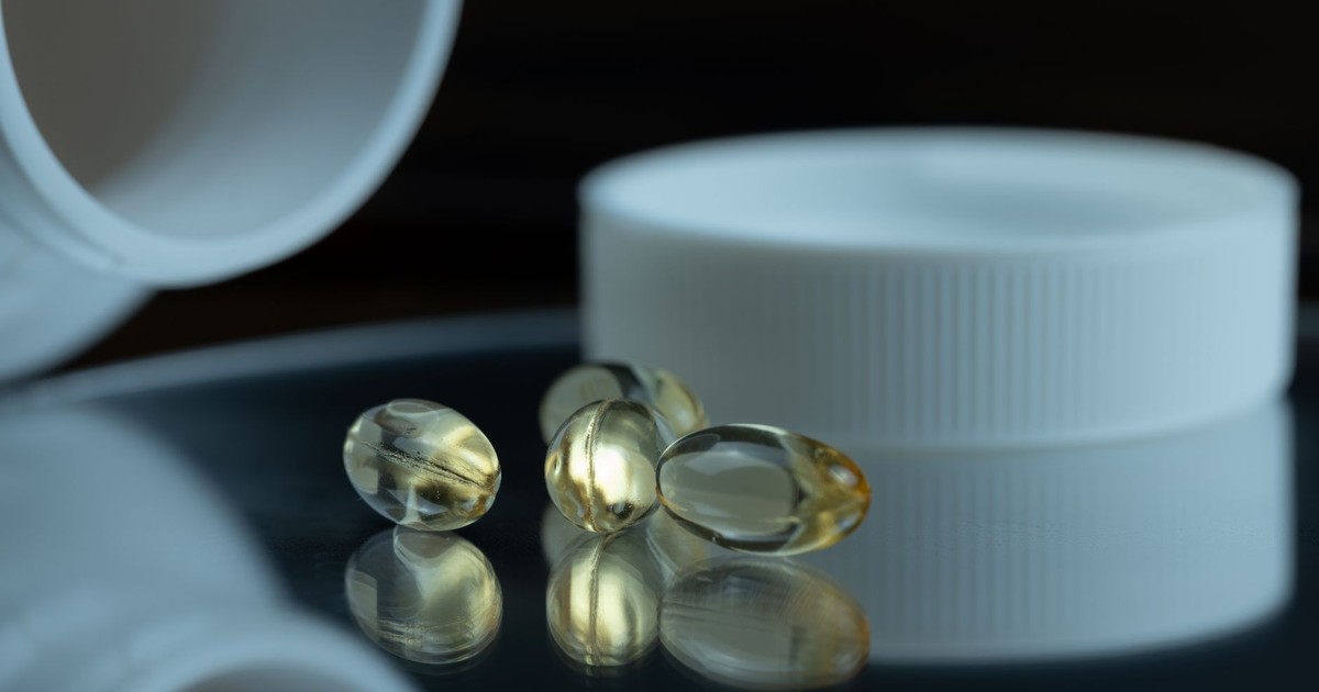 Focused image of gel capsules with a white bottle cap, emphasizing health and supplements.
