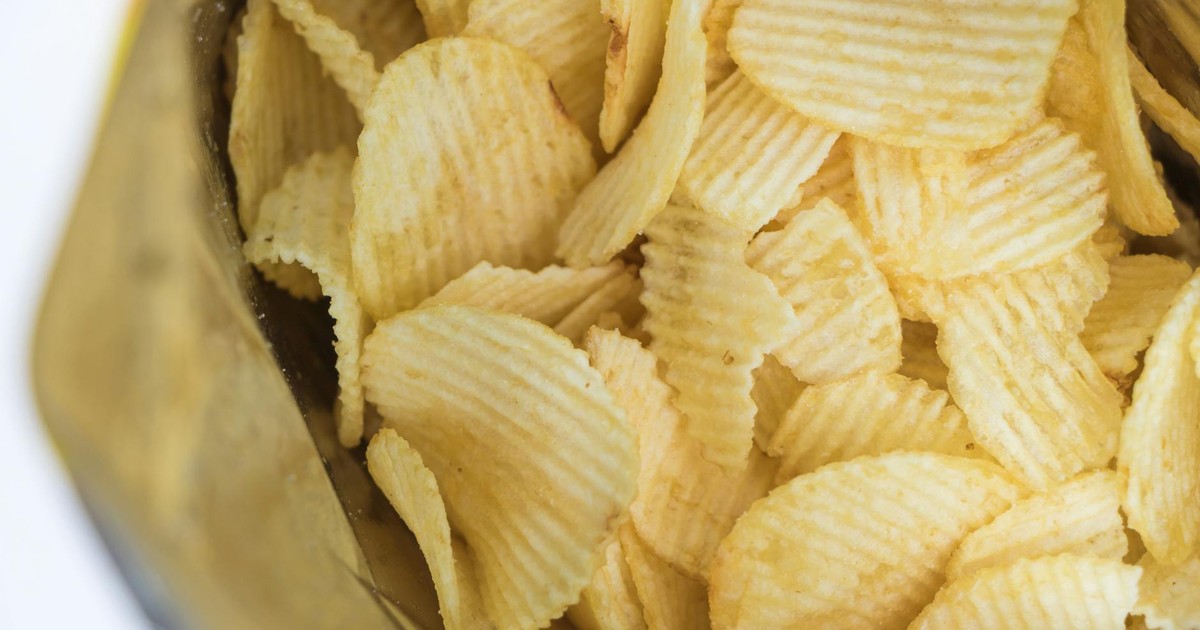 Close-up of ridged potato chips in an open bag, showcasing texture and crunch.