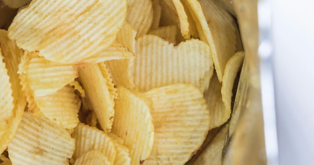 Close-up of ridged potato chips inside an opened snack bag, ready to eat.