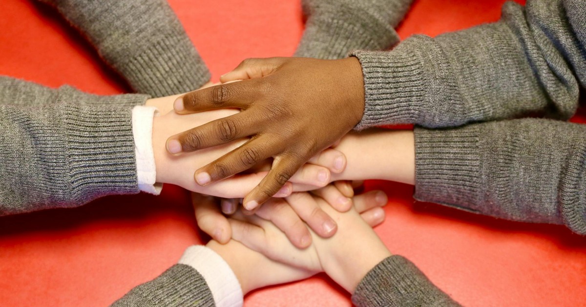 Close-up of diverse hands joining together, symbolizing teamwork, unity, and support.
