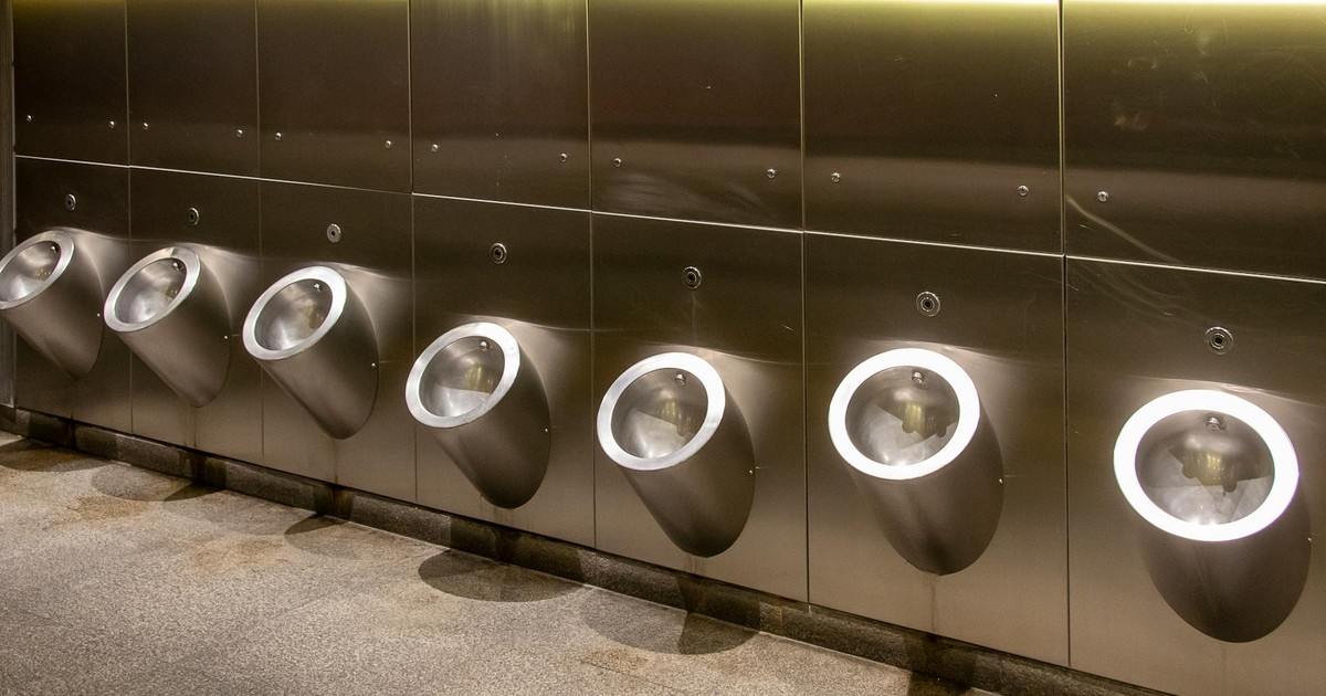 Row of modern stainless steel urinals in a public bathroom, clean and minimalistic design.
