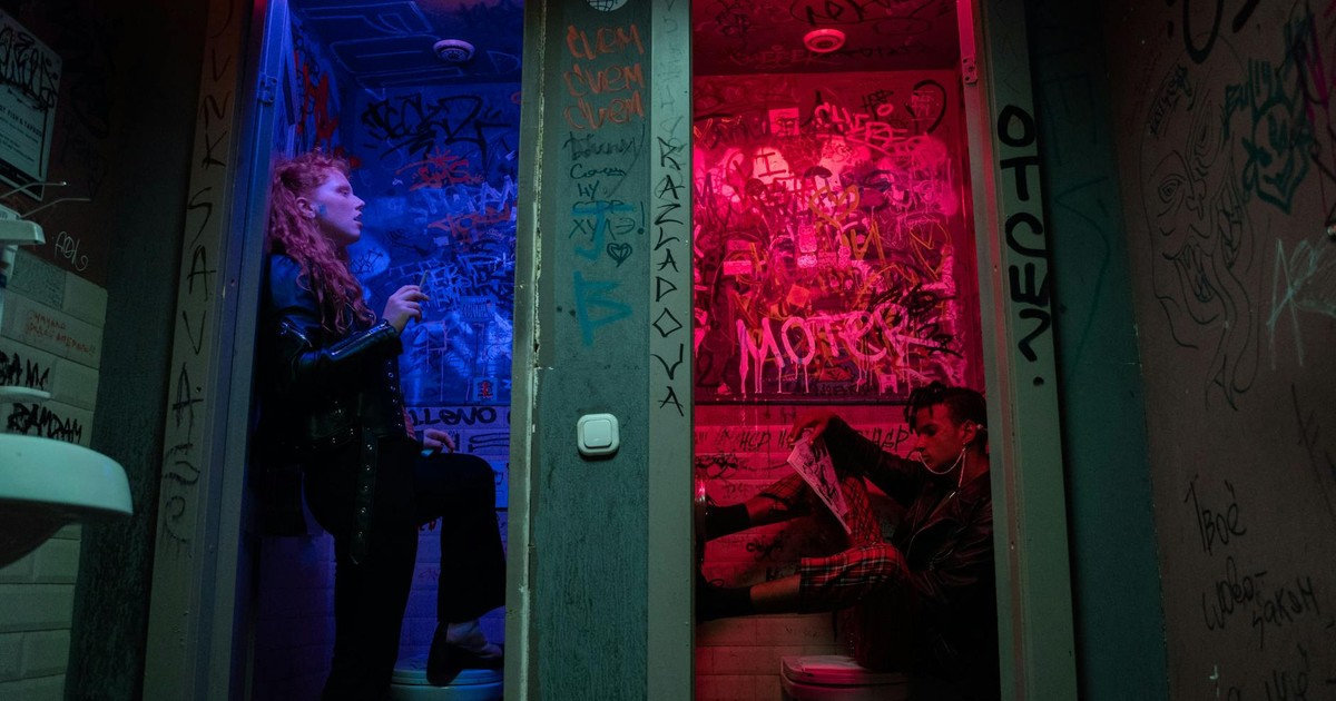Punk-inspired image of individuals in vibrant, graffiti-covered restrooms, exuding rebellious energy.