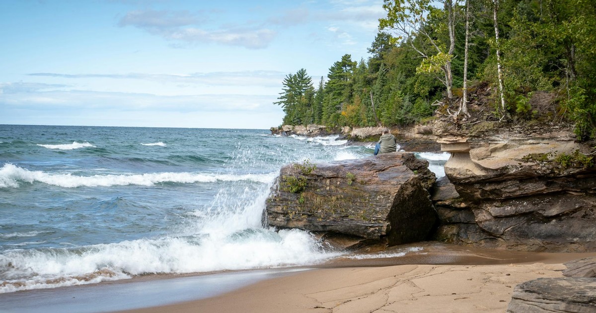 Dramatic waves crash against the rocky coastline of Lake Superior, capturing Michigan's natural beauty.