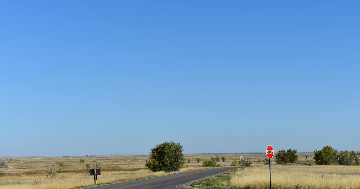 Quiet rural road intersection with a stop sign in South Dakota's open plains.