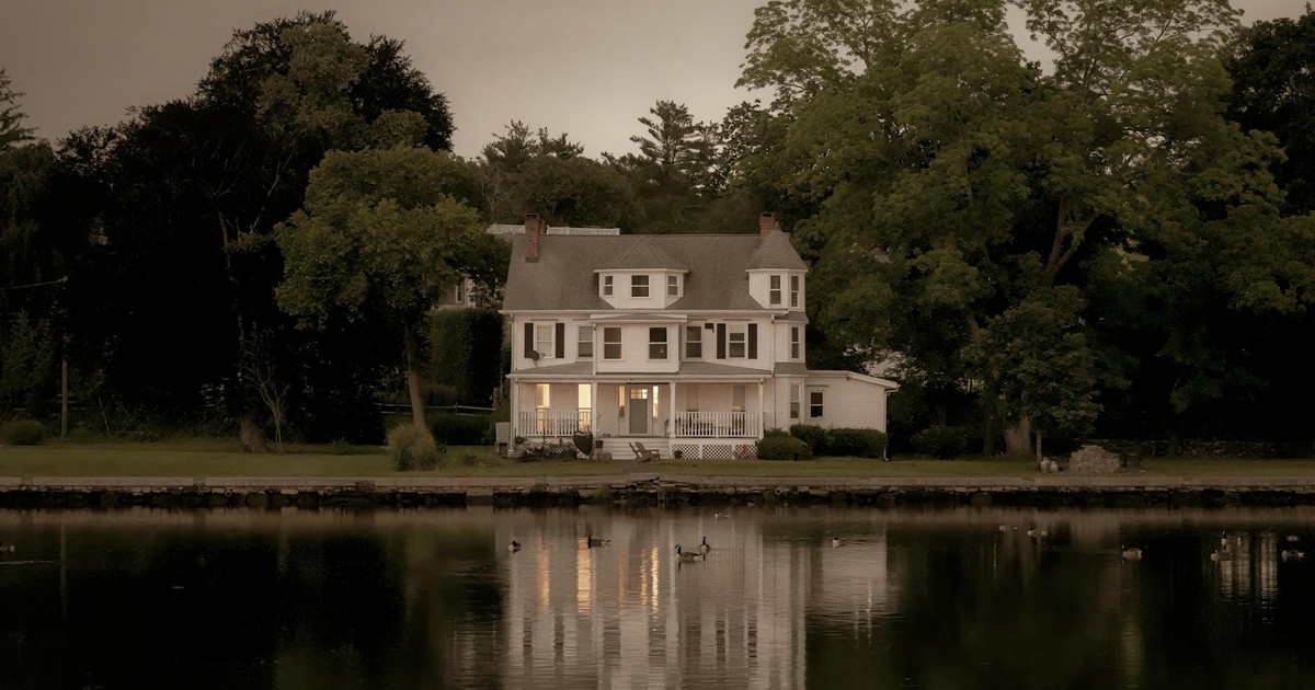 A serene view of a colonial house reflecting on water at twilight in Stamford, Connecticut.