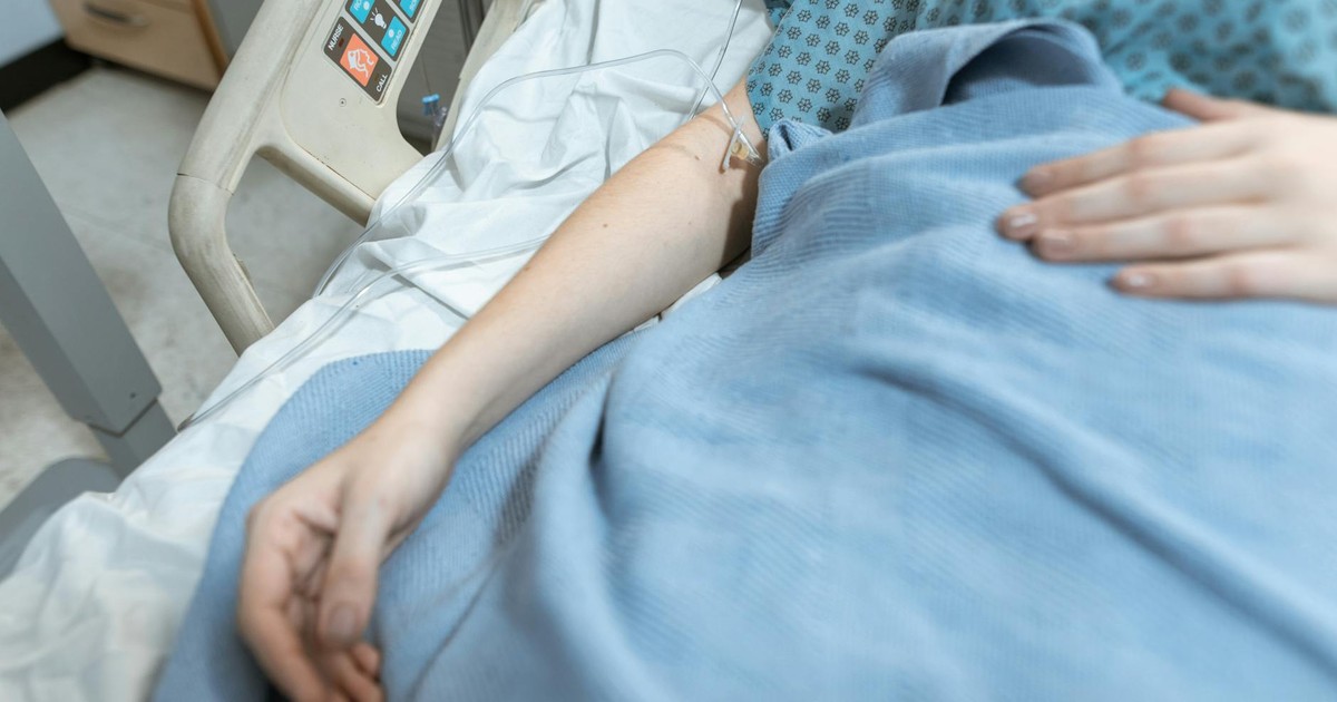 A close-up of a patient in a hospital bed receiving intravenous treatment, conveying healthcare and recovery.
