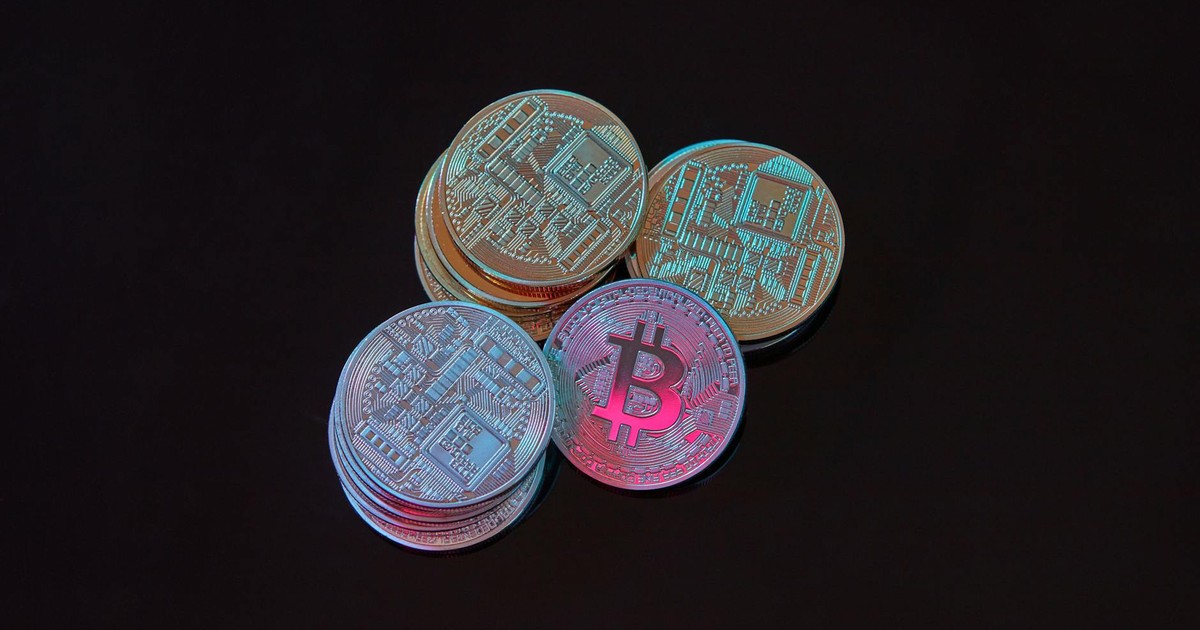 A detailed image showcasing a stack of Bitcoin cryptocurrency coins on a black background.