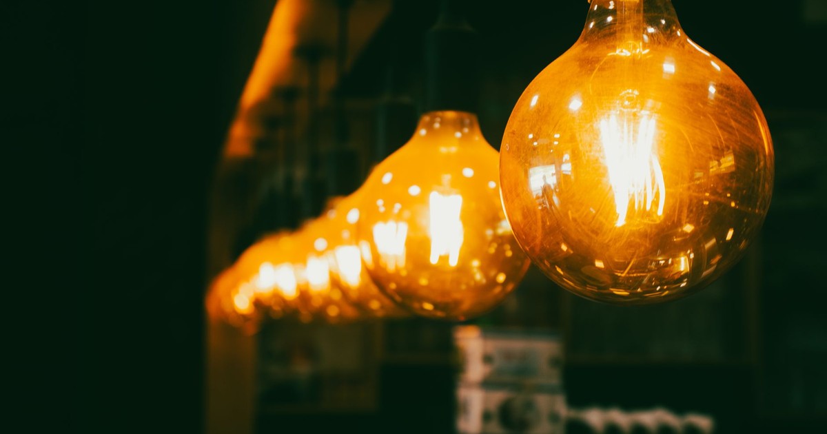 Close-up view of vintage light bulbs emitting a warm glow in a dim indoor setting.