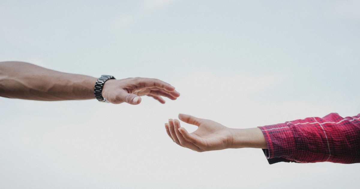 Two hands reaching towards each other, symbolizing connection and support.