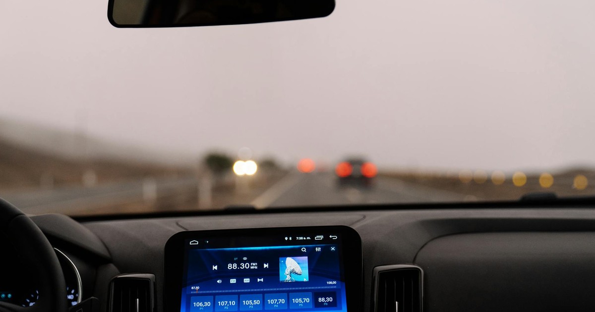Interior view of a car dashboard on an open road during the day. Perfect for travel-themed projects.