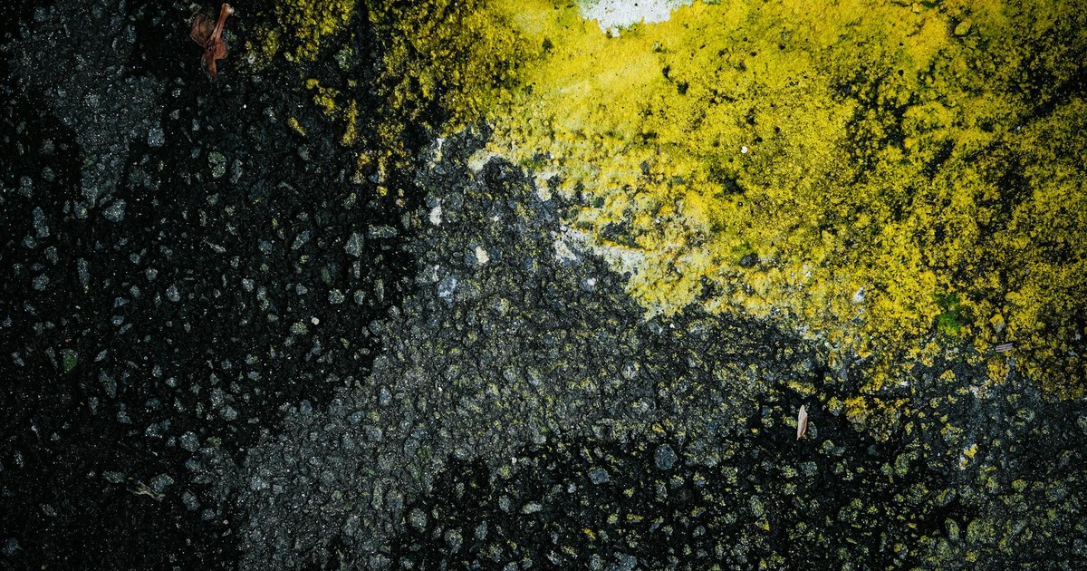 High-contrast texture of urban pavement with striking yellow and black hues in Jakarta.