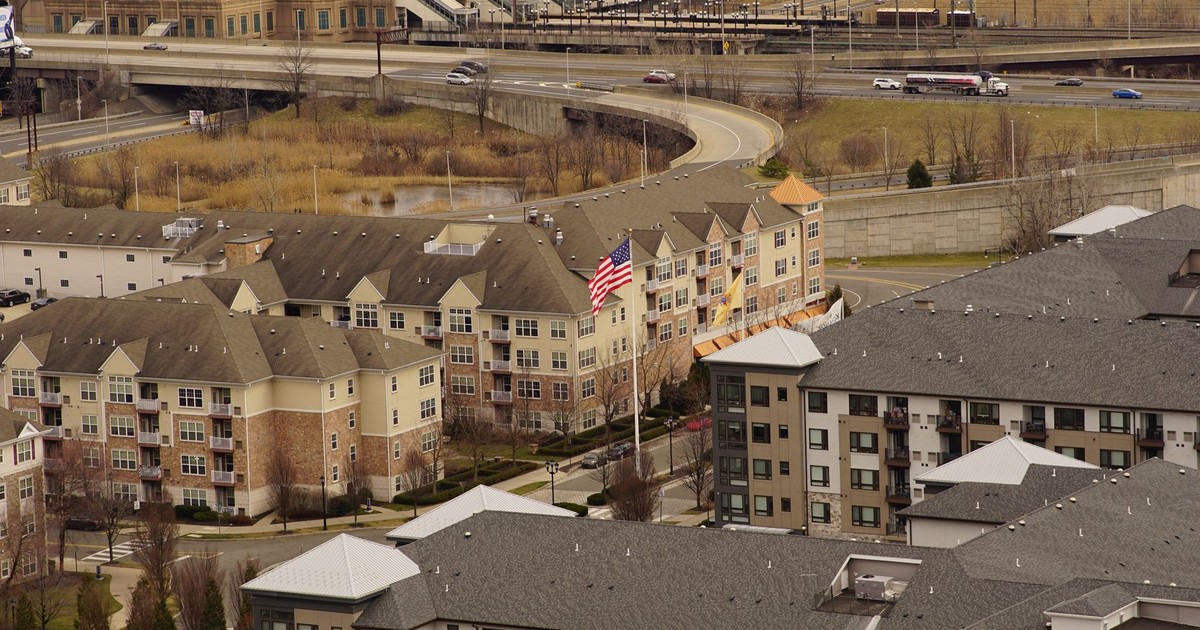 Aerial view of urban residential apartments featuring an American flag, depicting city life.