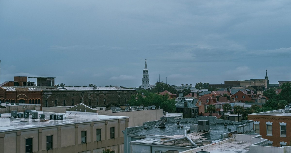 Aerial cityscape of Charleston, SC showcasing historic architecture under a cloudy sky.