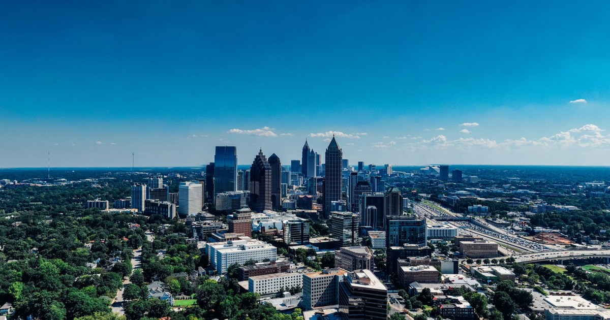 A stunning aerial shot of Atlanta's skyline with clear blue skies and urban landscape.