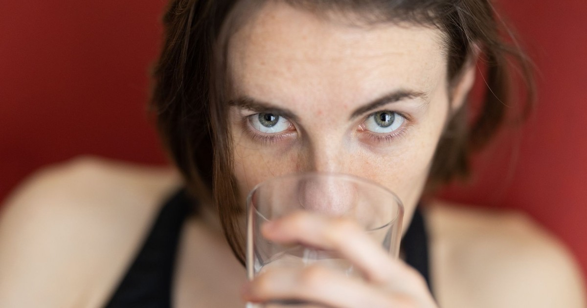 A young woman drinking water, offering a close-up view with a soft focus on her expression.