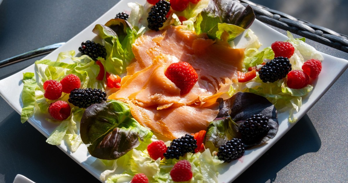 Delicious salmon and berry salad served on a plate, perfect for a healthy summer meal.