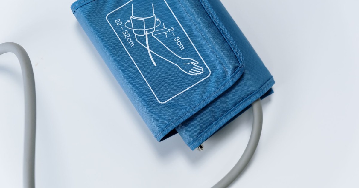 Close-up of a blue blood pressure cuff on a white surface, medical equipment for health monitoring.