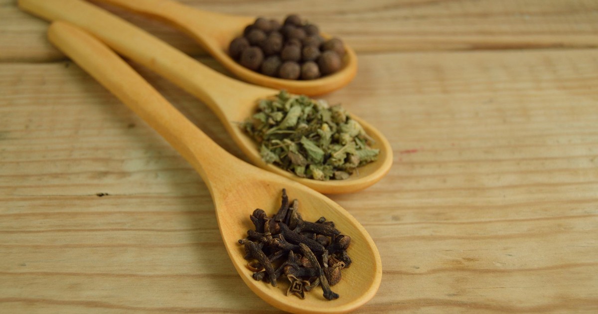 Close-up of wooden spoons on a table filled with aromatic spices.
