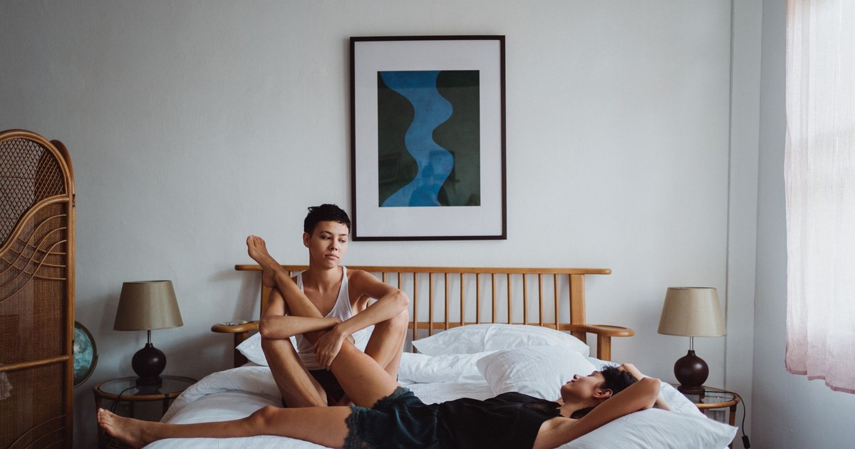 A couple enjoys a tranquil moment in a stylish, minimalist bedroom setting.