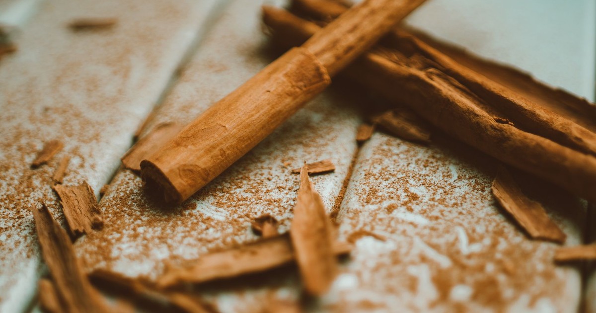 A detailed close-up image of cinnamon sticks and ground cinnamon on a wooden surface, highlighting texture and aroma.