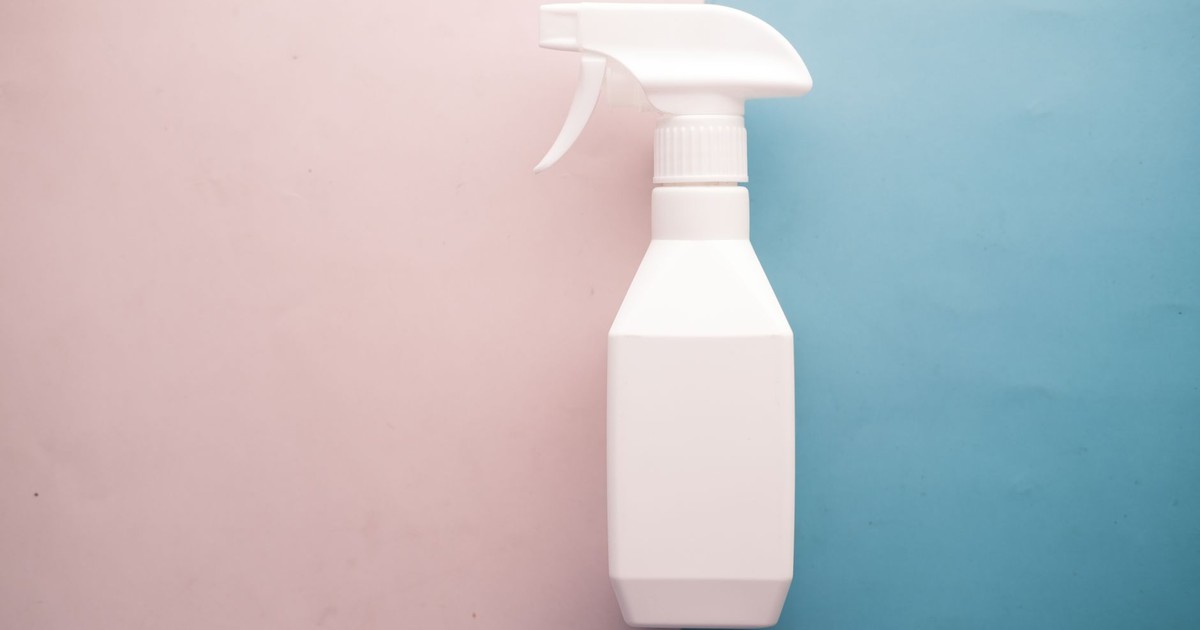 White spray bottle on pink and blue background with copy space, perfect for product mockups.